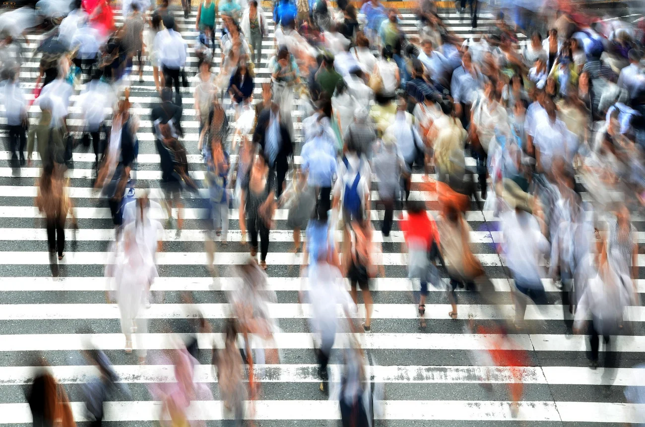 An urban street full of people who don't look at each other — the structural loneliness of modern cities
